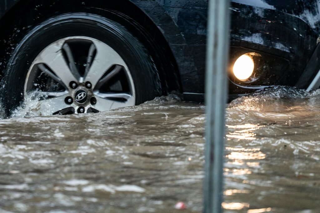 Car driving through floodwater splashes