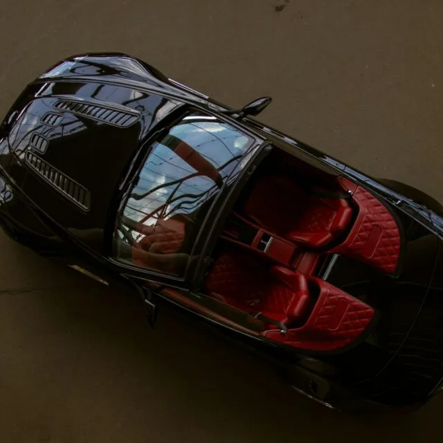 an overhead view of a black car with red seats